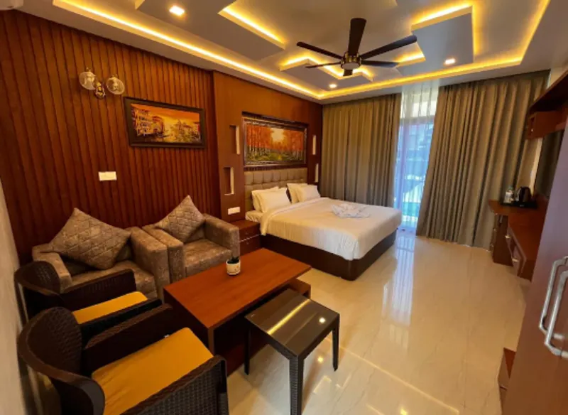 Deluxe Pool View Room with a double bed and armchairs