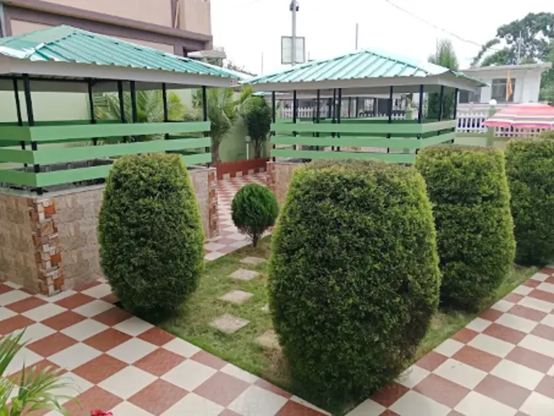 Green-roofed garden cottages with clipped hedges