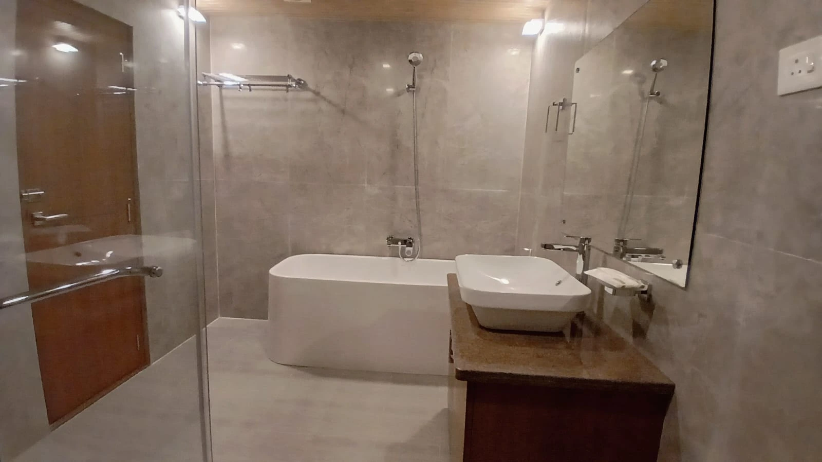 Grand Pool View Suite bathroom with freestanding bathtub and glass shower