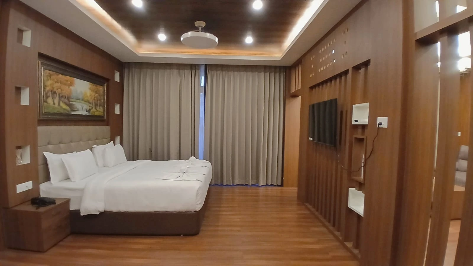 Grand Pool View Suite bedroom with wood-panelled walls and double bed